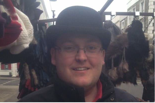 Iain Gordon, Digital, Data and Technology Fast Streamer, standing outside next to the rail of hats