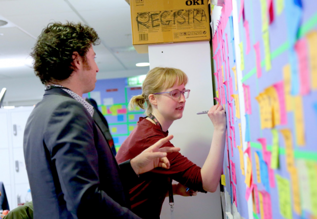 Colleagues are writing on the post-it wall 