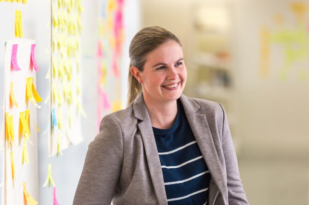 Abi Giles-Haigh, Senior Data Scientist, next to a post-it wall