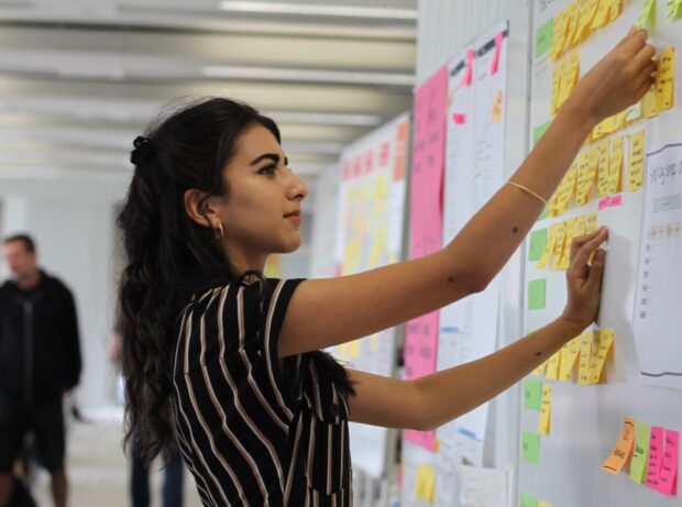 An intern attaching the post-it note on the board