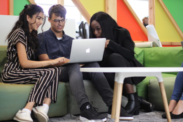 Interns discussing their work on a laptop