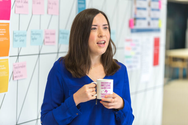 Helen Morris, holding a cup in an office