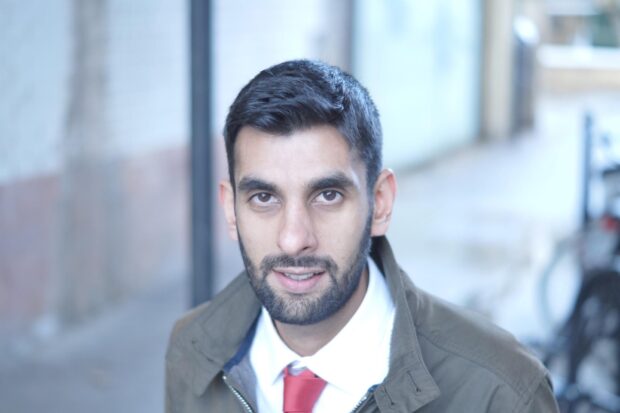 Khidr Suleman standing in front of a window in an office environment