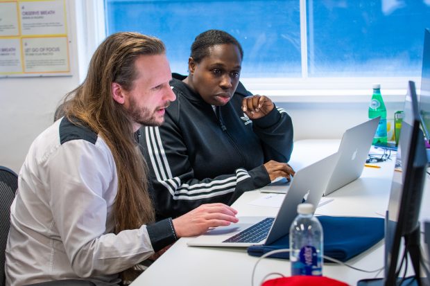 Software Development apprentices are interacting and looking at the laptop