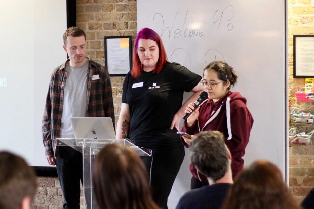 Three apprentices standing in front of a room full of people 