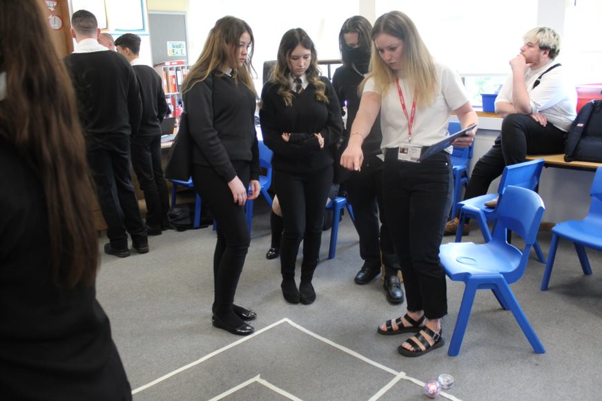 Image of school girls planning routes for robots at STEM skills teaching sessions